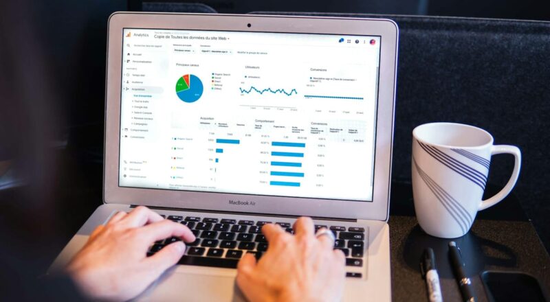 Nutzer analysiert Website-Daten mit Google Analytics Dashboard auf dem Laptop